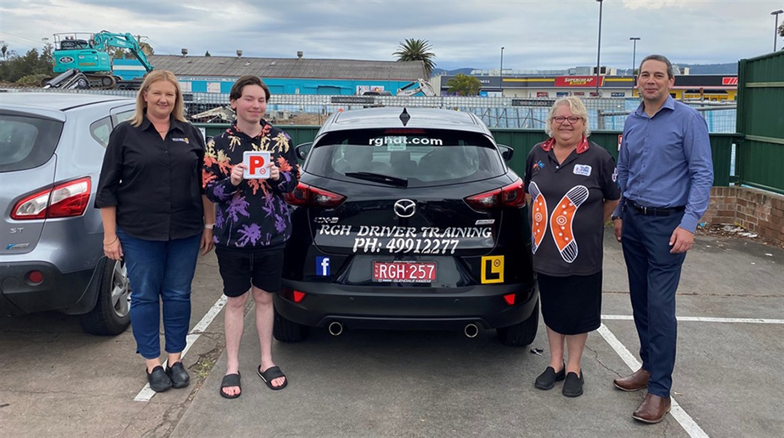 Image of Danielle O'Hara (RGH Driver Training), Ryan Hodgins, Teresa Hughes (Youth Express) and Cessnock City Council's Economic Development and Tourism Manager Tony Chadwick. They are standing in front of a car and Ryan is holding his P plates.
