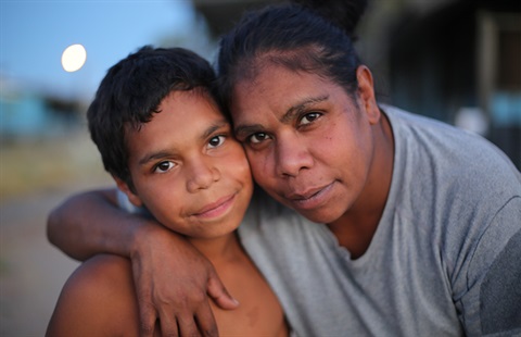 Middle age Indigenous woman hugging a young Indigenous boy