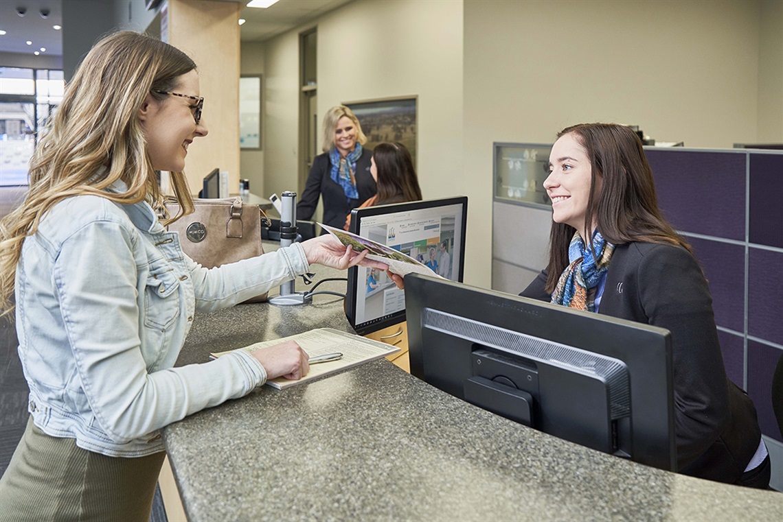 Image of a customer talking to a Cessnock City Council Customer Service team member at the service counter in Council's Administration building