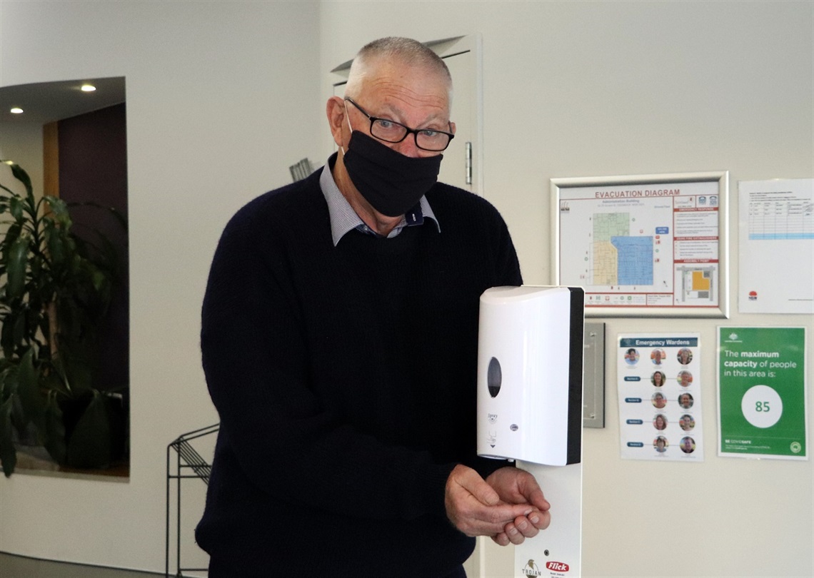 Mayor Pynsent wearing a mask and using a hand sanitising station.